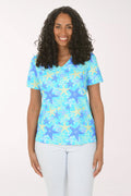Woman wearing a blue starfish patterned shirt on a white background