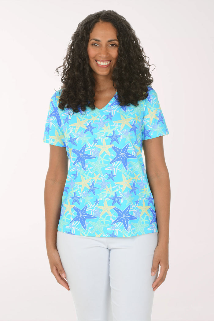 Woman wearing a blue starfish patterned shirt on a white background