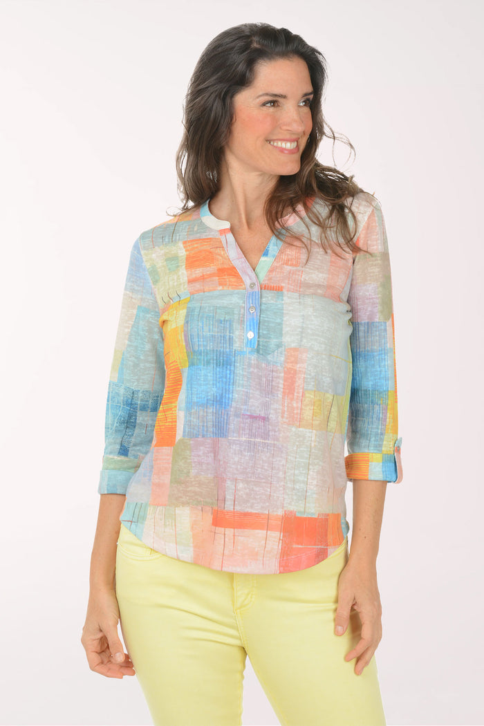 A woman wearing a multicolored plaid 3/4 sleeve top.
